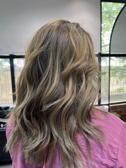 A closer view of the ash blonde waves, showing the dimension and texture achieved through careful coloring and styling.