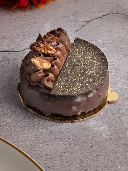 A beautifully presented vegan chocolate and walnut pastry. The combination of rich chocolate, crunchy walnuts, and delicate gold dusting makes it a truly gourmet vegan treat.