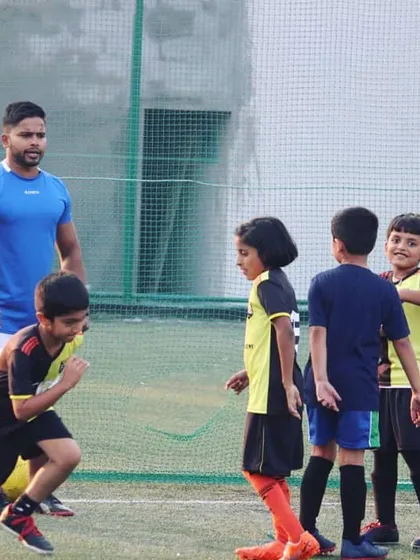 Our coach shares a lighthearted moment with the team during a training session. Building strong, positive relationships is key to our mentorship approach, making learning football fun and engaging.