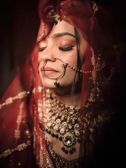 A close-up bridal portrait focusing on the serene expression and intricate details of the jewelry. We use moody lighting to create a timeless and elegant feel.