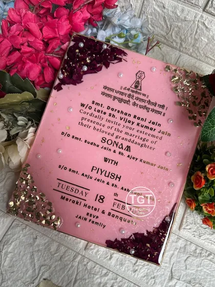 Another perspective of the pink resin invitation, capturing the shimmer of the base and the texture of the floral corners.