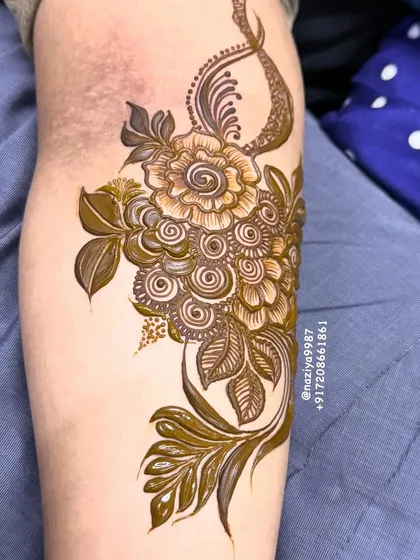 A gorgeous floral bunch design for the arm. The mix of shaded flowers and delicate leaves creates a beautiful composition.