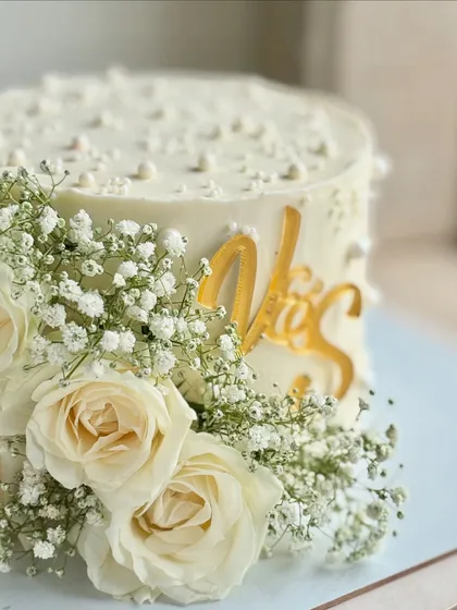 A close-up view of the floral arrangement and the elegant gold 'V&S' topper, showing how the elements come together to create a soft, romantic look.