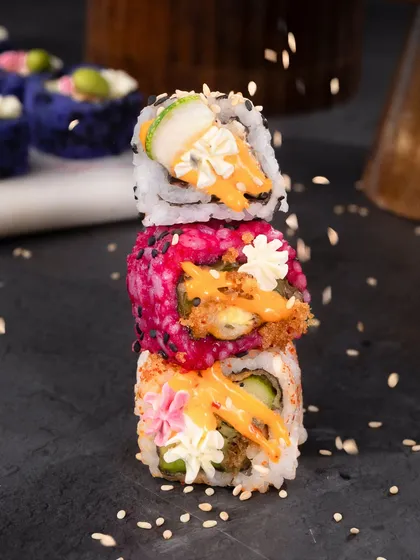 Who says vegetarian food can't be a work of art? I love creating dishes that are as beautiful as they are delicious. This stack of my signature sushi rolls shows the variety and creativity I bring to the table, using natural ingredients to create stunning colours and flavours.