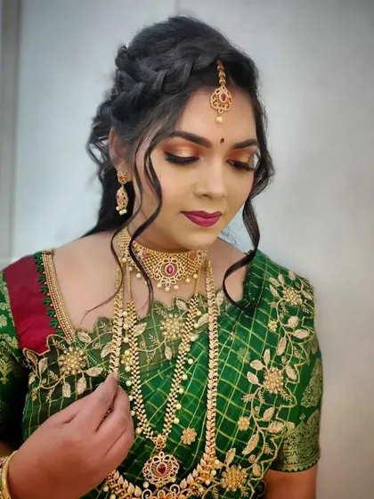 A stunning reception or sangeet look featuring a bronze smokey eye and braided hairstyle. This demonstrates the versatility our students gain, allowing them to cater to all wedding-related events.