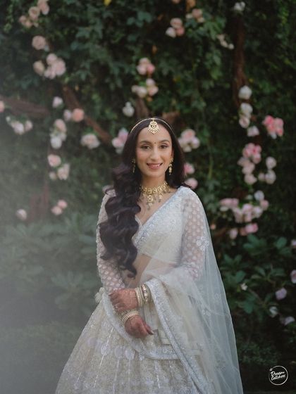 A smiling bride against our romantic floral wall. The soft focus and gentle colors of the flowers create a dreamy and ethereal portrait.