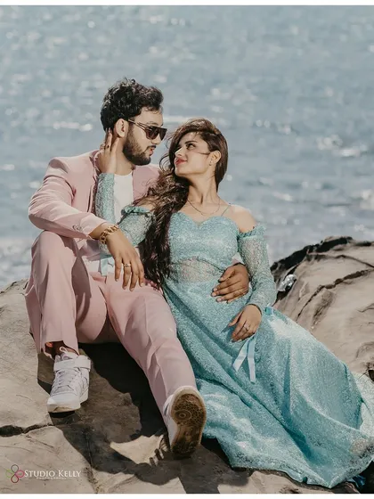 A sweet, intimate moment on the rocks by the sea in Goa. The soft colors of their outfits complement the coastal setting beautifully, making for a gentle and romantic portrait.
