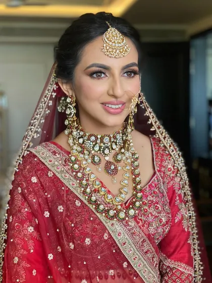 Your bridal makeup dreams begin here. We created a fresh glam look for this bride in red, with a soft base, a hint of glamour on the eyes, and a gorgeous messy bun.