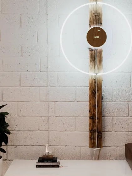 More than a clock, our STORY timepiece is a piece of kinetic art. This setup shows its potential as a large, wall-mounted installation, with the levitating sphere orbiting a wooden disc, creating a stunning visual focal point in any room.