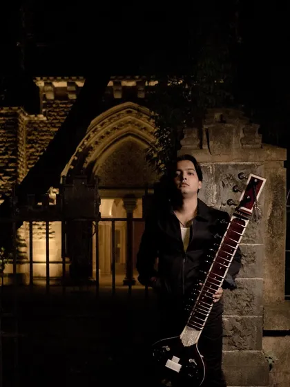 Posing in front of a historic building at night, the perfect backdrop for a fusion track.