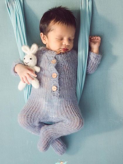 A sweet smile from this sleeping baby, comfortably posed in a hanging sling. This pose is wonderful for showing how tiny and peaceful they are.