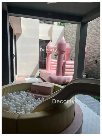 Fun and games are a must! This setup includes a ball pit with a slide and a pink bouncy castle, perfect for a fairy or princess-themed party.