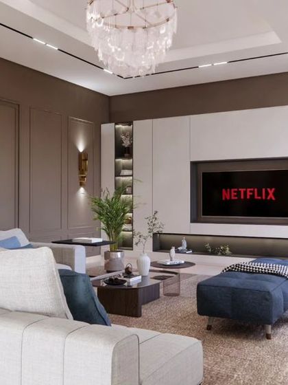 A different angle of the Brigade Orchards living room, showing the comfortable L-shaped sofa and the elegant chandelier that adds a touch of classic luxury.