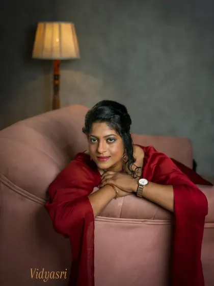 A different angle from Vidyasri's session, this portrait includes the warm glow of a vintage lamp. It adds a layer of intimacy and nostalgia to the scene, framing her in a comfortable, reflective moment that feels like a page from her personal story.
