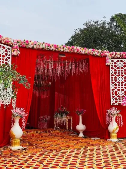 A beautiful entrance view leading to the red stage, with hanging floral arrangements and lattice panels.