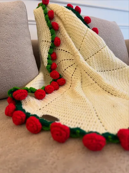 Our rose bouquet blanket, draped over a couch. The 3D roses along the border make this a stunning statement piece for your home.