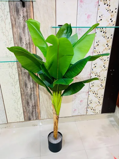 A tall artificial banana tree with large, vibrant leaves, bringing a tropical and exotic vibe to any room.