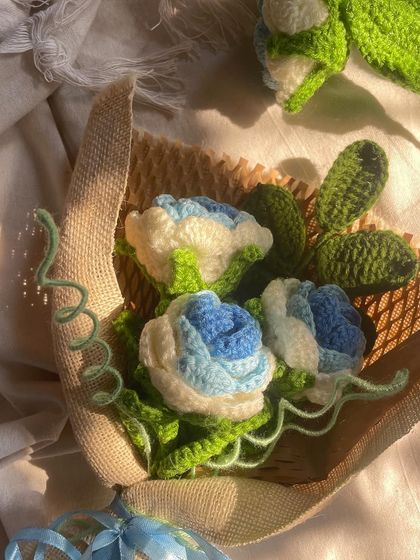 A close-up of the blue and white bouquet, showing the intricate details of the petals and leaves.