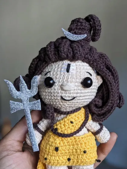 My handmade Lord Shiva doll, held in hand to show its size. It features his Trishula, the crescent moon, and matted hair.