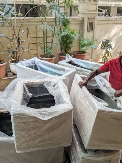 A team member carefully unpacks the bubble-wrapped planters upon arrival at the client's residence in Juhu. We ensure every item is delivered and handled with the utmost care.