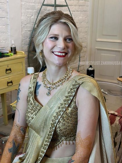A candid shot of an international bride smiling, with her hair styled in a textured blonde updo. This shows the hairstyle in a real, joyful moment.