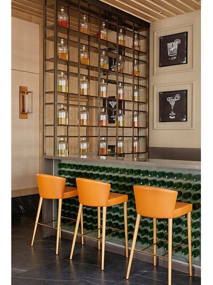 The custom-designed bar at the Rustomjee Elements banquet. The front of the counter is made from green glass bottles, and the back bar features a metal framework with quirky, chalkboard-style graphics.
