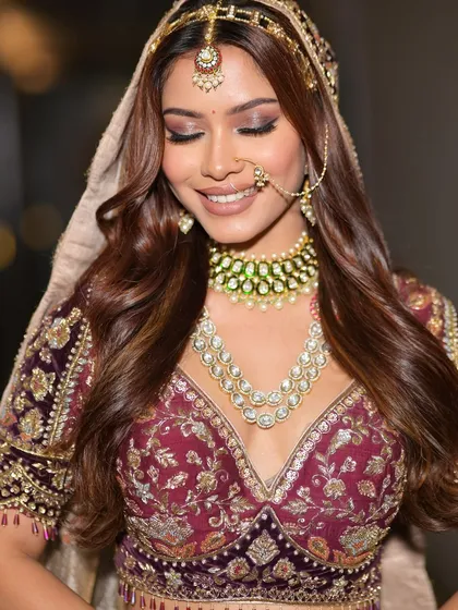 A happy, candid moment that captures the bride's radiant smile. The soft glam makeup enhances her features beautifully, creating a look that is both joyful and elegant.