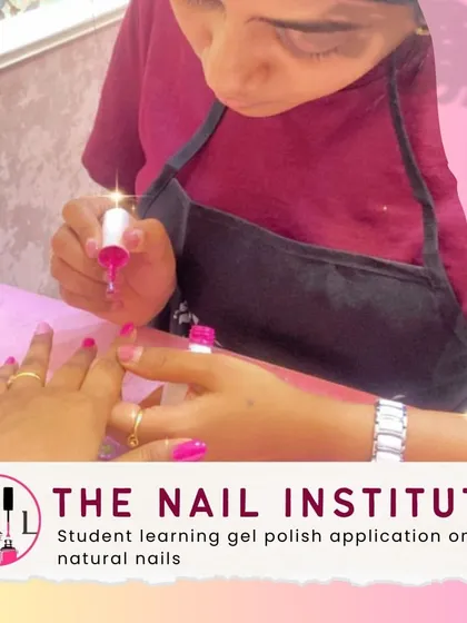 A student practices applying gel polish on natural nails, focusing on achieving a smooth, even coat without flooding the cuticles.