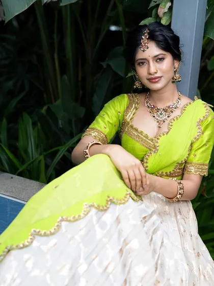 Wrapped in elegance, this half saree features a light gold tissue lehenga paired with a vibrant lime green princess katori blouse. The entire ensemble, including the dupatta, is finished with intricate handwork for a look of traditional grace.