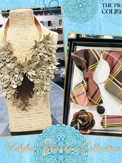 This coordinated gift set includes a men's accessory box with a brown and pink plaid bow tie and tie. It is paired with a detachable collar for women, featuring intricate beige 3D floral details.