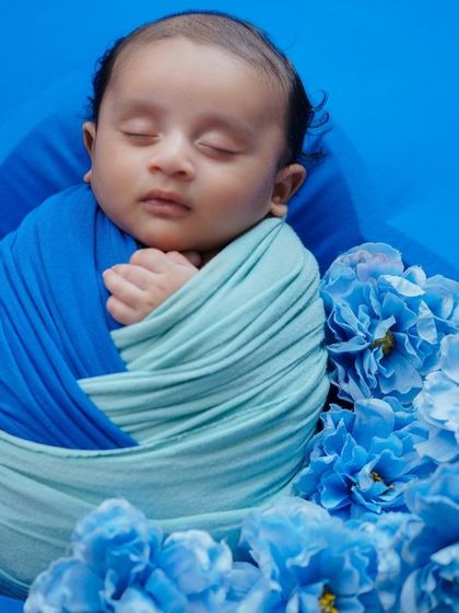 A sea of blue. This photo shows a baby swaddled in two tones of blue, creating a beautiful, ocean-like effect.