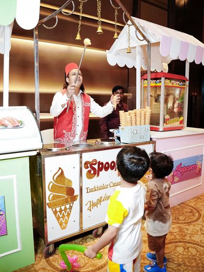 Kids excitedly waiting for a treat from the Turkish ice cream vendor, a fun and interactive food experience.