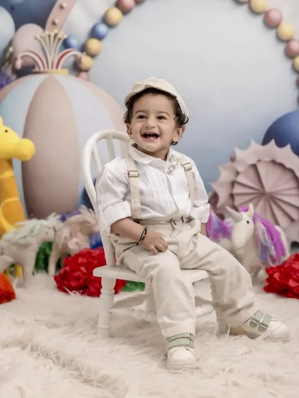 A bright smile for a big milestone. This little boy is all dressed up and ready to party in our colorful and imaginative fantasy-themed studio set.