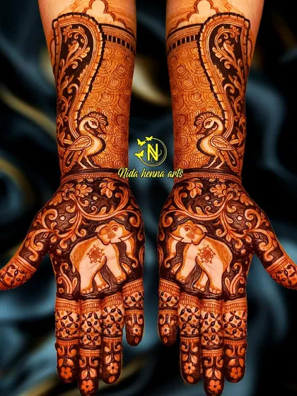 A designer mehandi featuring an animal theme. This symmetrical design has majestic elephants on the palms and graceful peacocks on the wrists, perfect for a bride who loves traditional motifs.