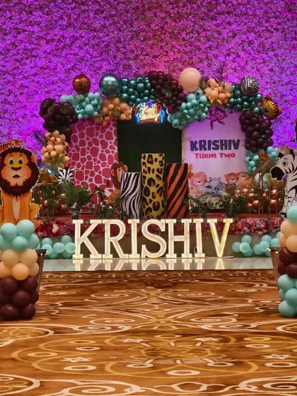 A grand jungle-themed stage for a second birthday party. I used animal print props, character cutouts, marquee letters, and a lush balloon arch to create a vibrant safari look.