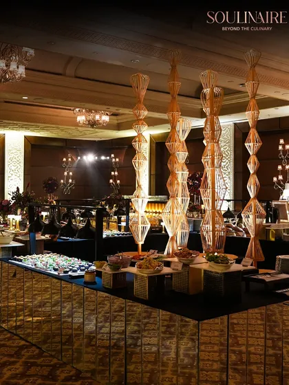 A magnificent buffet setup featuring a mirrored counter that reflects the opulence of the event. This grand display showcases our ability to cater to large-scale gatherings with elegance and an abundance of gourmet choices.
