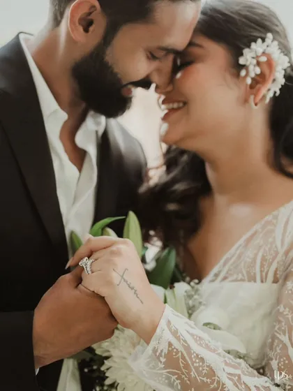 An intimate portrait focusing on the couple's hands and faces. The detail of her "faith" tattoo on her hand adds a layer of personal meaning to this romantic pre-wedding photo.
