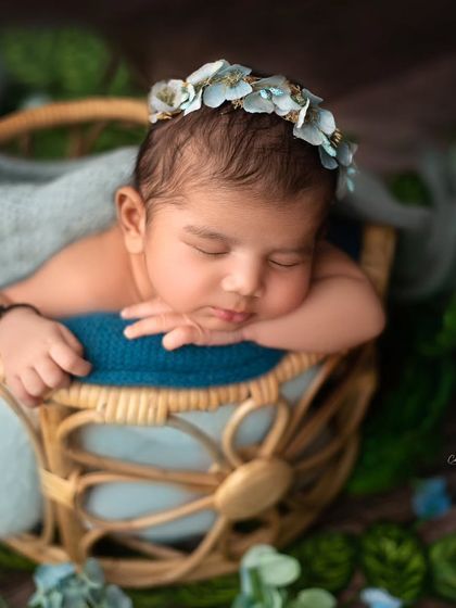 Another angle of this peaceful baby in a basket. This pose, with hands tucked under the chin, is classic and always so adorable.