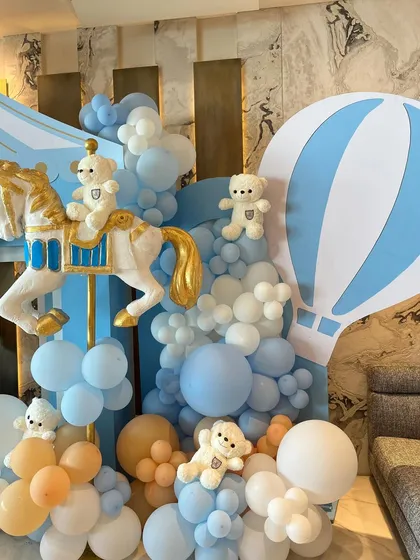 The decor included charming details like hot air balloon props, "BABY" blocks, and teddy bears riding the carousel horses, all in a soft, gentle color palette.