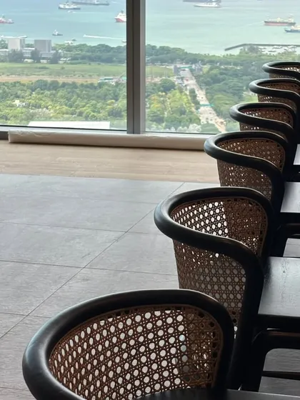 A view of the caned bar stools in a high-rise building, overlooking the city.