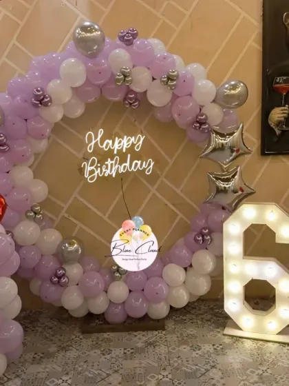 A purple and white balloon ring with silver accents and heart-shaped foils for a 6th birthday.
