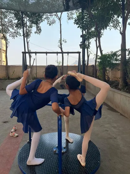 Ballet in the park. Two of our students using the merry-go-round as a prop for their arabesques.