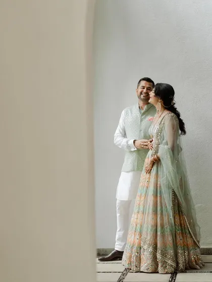 A candid moment of affection. The couple's easy laughter and gentle embrace are the focus here, with the clean, minimalist background keeping the mood intimate and personal.