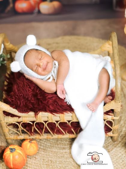 A precious sleepy smile captured in a moment of deep slumber. The baby's cozy bear bonnet and the warm, rustic setting make this an incredibly heartwarming and sweet newborn portrait.