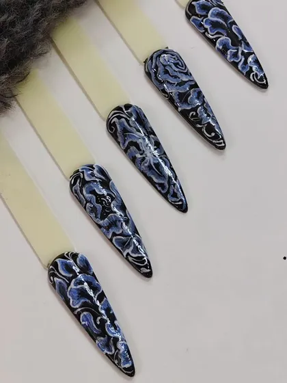 An example of intricate, hand-painted floral patterns on long stiletto practice tips. This shows the level of detail I can achieve.