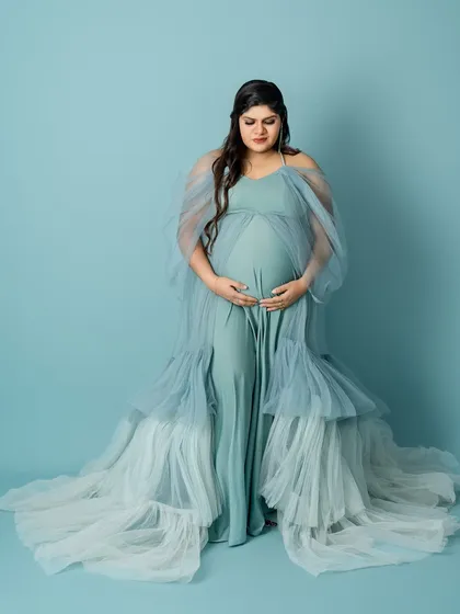 This full-length portrait showcases the incredible texture and flow of the layered blue gown, creating a truly show-stopping image.