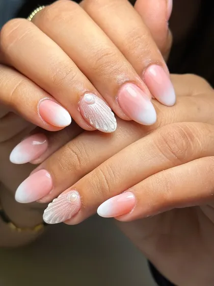 Seamlessly blending into beauty. A perfect ombre on almond-shaped nails with a 3D seashell accent and a single pearl.