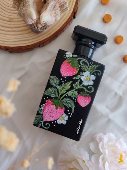 A perfume bottle hand-painted with fresh strawberries and blossoms. This design adds a touch of whimsy and freshness, creating a truly unique piece.
