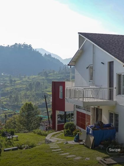 An exterior shot showing the relationship between the house, the garden, and the vast hilly landscape beyond.