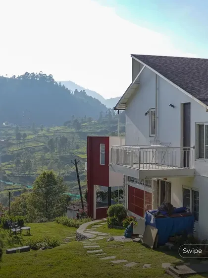 An exterior shot showing the relationship between the house, the garden, and the vast hilly landscape beyond.